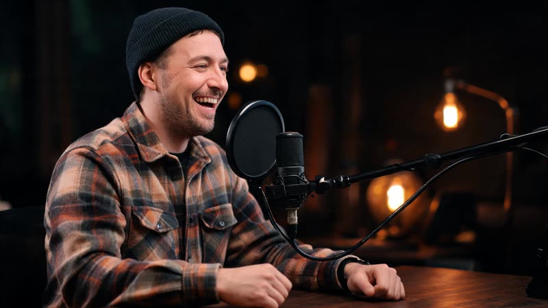 A podcaster speaking into a studio microphone